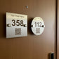 Two hotel room number signs with QR codes on a white wall.