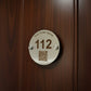 Metal hotel room key tag with number 112 and QR code on a white background