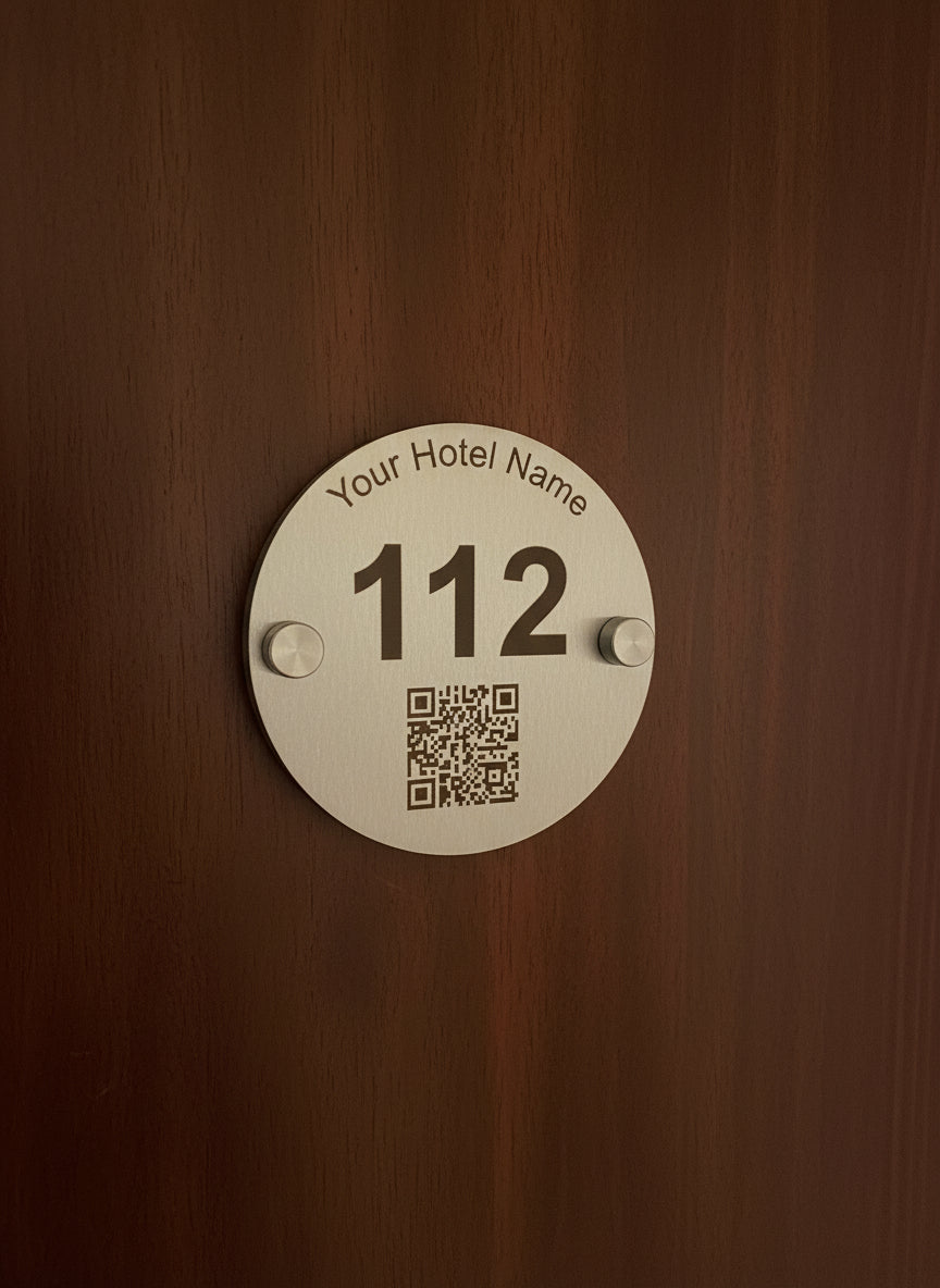 Round metal hotel room keycard with QR code and placeholder text 'Your Hotel Name' on a white background