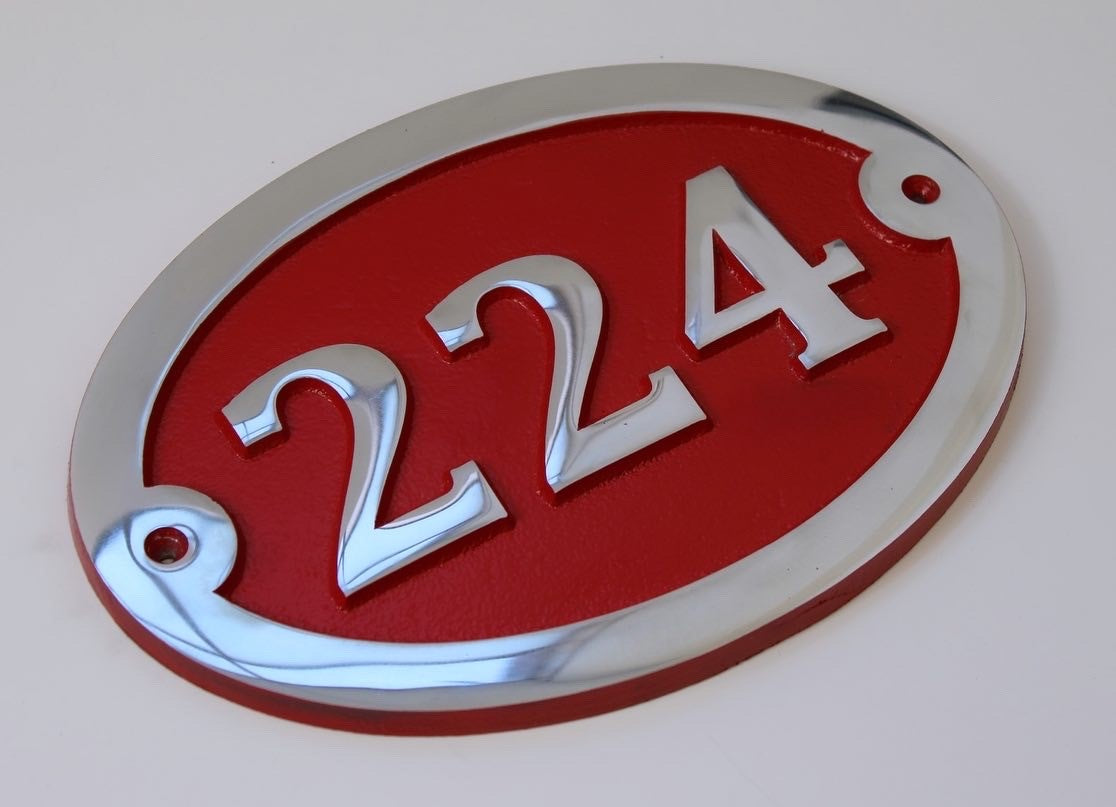 House number sign in oval with red background