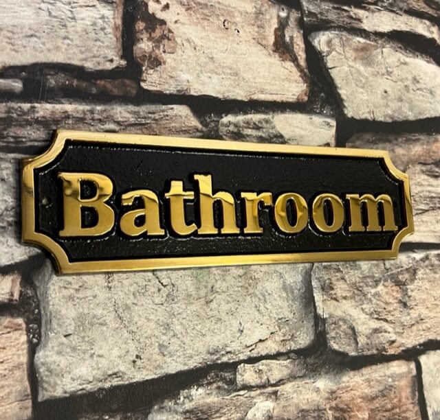 bathroom sign in bronze